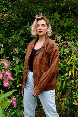 Rotbraune 90s Bomberjacke aus echtem Leder in schwerer Qualität, unisex tragbar: zu empfehlen für eine heutige Herren-L, für Damen empfehlen wir die Jacke einer L bis XL je nach gewünschter Passform; ideal für große Körpergrößen – mit Reißverschlüssen an den Schultern und dadurch auch als Weste tragbar – ein absolutes Highlight