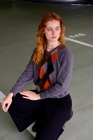 Grauer 90s Wollpullover mit V-Kragen und Rautenmuster in Rost/Orange, Hellgrau, Dunkelgrau, Schwarz und Brauntönen – für einen lockeren Look empfehlen wir den Pullover einer S/M