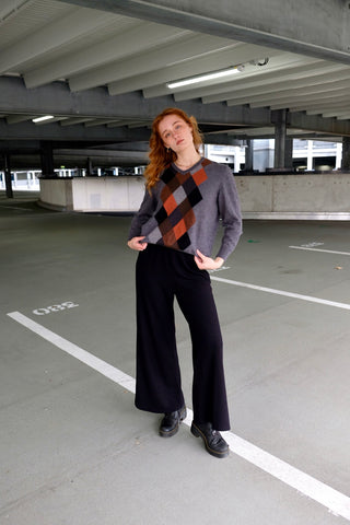 Grauer 90s Wollpullover mit V-Kragen und Rautenmuster in Rost/Orange, Hellgrau, Dunkelgrau, Schwarz und Brauntönen – für einen lockeren Look empfehlen wir den Pullover einer S/M