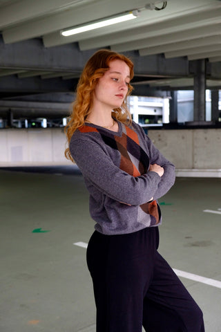 Grauer 90s Wollpullover mit V-Kragen und Rautenmuster in Rost/Orange, Hellgrau, Dunkelgrau, Schwarz und Brauntönen – für einen lockeren Look empfehlen wir den Pullover einer S/M