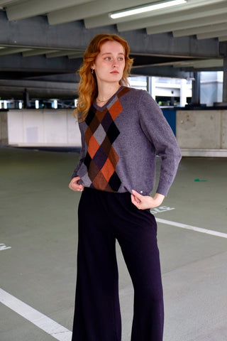 Grauer 90s Wollpullover mit V-Kragen und Rautenmuster in Rost/Orange, Hellgrau, Dunkelgrau, Schwarz und Brauntönen – für einen lockeren Look empfehlen wir den Pullover einer S/M