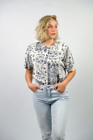 Locker geschnittene 90s Baumwollbluse mit Rundhalskragen, süßen Knöpfen in Mondform und Crazy Pattern Print in Weiß und Schwarz – für einen lockeren Look empfehlen wir die Bluse einer M bis L – ein absolutes Highlight