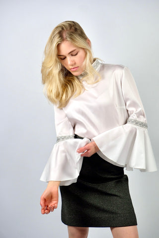Weiße 70s Bluse mit Stehkragen, Trompetenärmeln und silbernen Verzierungen, wird am Rücken mit einer Knopfleiste geschlossen – wir empfehlen die Bluse einer heutigen S bis M – ein seltenes Fundstück und absolutes Highlight