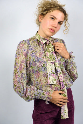 Halbtransparente, locker geschnittene 70s Bluse mit Schluppenkragen, tollen Puff-/Ballonärmeln sowie floralem Muster in Creme, Grün, Flieder und Pink/Rosa – ideal für eine heutige XS und ein absolutes Highlight