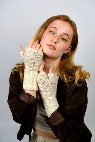 Handmade Handschuhe in fingerlosem Stil aus Schurwolle-Mix-Garn in Cremeweiß mit Zopfstrickdetails in Beige. Das Bündchen kann je nach Belieben auch umgeschlagen getragen werden.