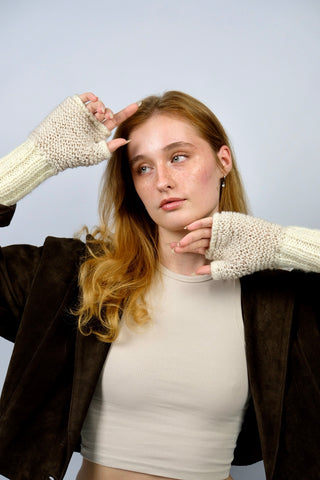 Handmade Handschuhe in fingerlosem Stil aus Schurwolle-Mix-Garn in Cremeweiß mit Zopfstrickdetails in Beige. Das Bündchen kann je nach Belieben auch umgeschlagen getragen werden.