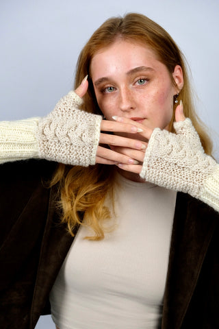 Handmade Handschuhe in fingerlosem Stil aus Schurwolle-Mix-Garn in Cremeweiß mit Zopfstrickdetails in Beige. Das Bündchen kann je nach Belieben auch umgeschlagen getragen werden.