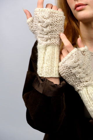 Handmade Handschuhe in fingerlosem Stil aus Schurwolle-Mix-Garn in Cremeweiß mit Zopfstrickdetails in Beige. Das Bündchen kann je nach Belieben auch umgeschlagen getragen werden.