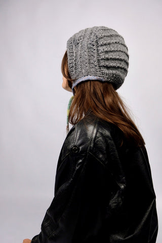 Handmade Bonnet aus Acryl-Garn in Grau mit bunten, schmalen Bindebändern.