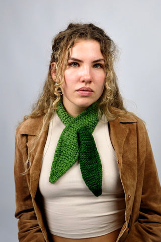 Handmade Minischal im Ascot-Stil aus weichem Acryl-Garn mit spitzen Enden sowie tollem Farbverlauf in Grüntönen. Wird durch eine kleine Öffnung auf einer Seite gesteckt, um ihn sicher am Hals zu halten.