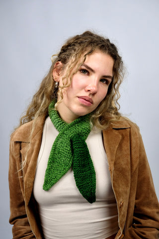 Handmade Minischal im Ascot-Stil aus weichem Acryl-Garn mit spitzen Enden sowie tollem Farbverlauf in Grüntönen. Wird durch eine kleine Öffnung auf einer Seite gesteckt, um ihn sicher am Hals zu halten.