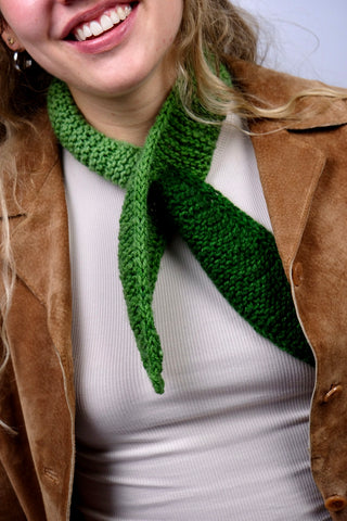 Handmade Minischal im Ascot-Stil aus weichem Acryl-Garn mit spitzen Enden sowie tollem Farbverlauf in Grüntönen. Wird durch eine kleine Öffnung auf einer Seite gesteckt, um ihn sicher am Hals zu halten.