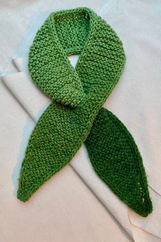 Handmade Minischal im Ascot-Stil aus weichem Acryl-Garn mit spitzen Enden sowie tollem Farbverlauf in Grüntönen. Wird durch eine kleine Öffnung auf einer Seite gesteckt, um ihn sicher am Hals zu halten.