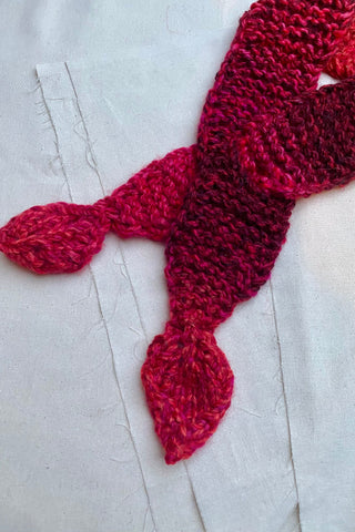 Handmade Minischal im Ascot-Stil aus Schurwolle-Mix-Garn mit Blatt-Details an den Enden sowie schönem Farbverlauf. Wird durch eine kleine Öffnung auf einer Seite gesteckt, um ihn sicher am Hals zu halten.