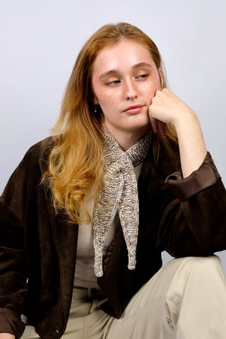 Handmade Minischal im Ascot-Stil aus Creme und Braun meliertem Bändchengarn mit Merino-Anteil. Wird durch eine kleine Öffnung auf einer Seite gesteckt, um ihn sicher am Hals zu halten.