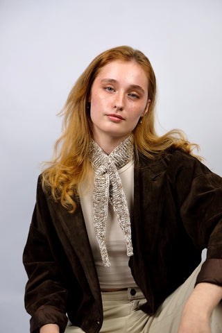 Handmade Minischal im Ascot-Stil aus Creme und Braun meliertem Bändchengarn mit Merino-Anteil. Wird durch eine kleine Öffnung auf einer Seite gesteckt, um ihn sicher am Hals zu halten.