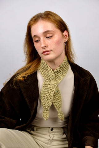 Handmade Minischal im Ascot-Stil aus pistaziengrünem, leicht meliertem Tweed-Garn mit Blatt-Details an den Enden. Wird durch eine kleine Öffnung auf einer Seite gesteckt, um ihn sicher am Hals zu halten.