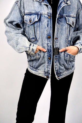 80s Acid Wash Jeansjacke im Bomberschnitt mit seitlichen Eingrifftaschen sowie Schriftzug und Patch auf dem Rücken – unisex tragbar, für einen lockeren Look empfehlen wir die Jacke einer S/M (bitte Maße beachten) – ein absolutes Highlight