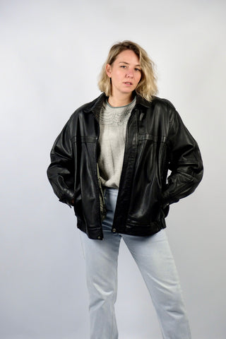 Schwarze 90s Bomberjacke aus echtem Glattleder mit Reißverschluss, Druckknöpfen und seitlichen Eingrifftaschen; toll erhalten und unisex tragbar – wir empfehlen die Jacke einer heutigen XL und ausschließlich für große Körpergrößen (bitte Maße beachten) – ein absolutes Highlight