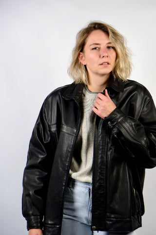 Schwarze 90s Bomberjacke aus echtem Glattleder mit Reißverschluss, Druckknöpfen und seitlichen Eingrifftaschen; toll erhalten und unisex tragbar – wir empfehlen die Jacke einer heutigen XL und ausschließlich für große Körpergrößen (bitte Maße beachten) – ein absolutes Highlight