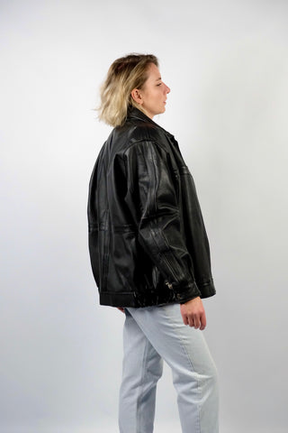 Schwarze 90s Bomberjacke aus echtem Glattleder mit Reißverschluss, Druckknöpfen und seitlichen Eingrifftaschen; toll erhalten und unisex tragbar – wir empfehlen die Jacke einer heutigen XL und ausschließlich für große Körpergrößen (bitte Maße beachten) – ein absolutes Highlight