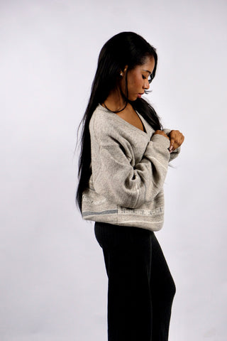 Greige (Grau-Beige) melierter 90s Pullover aus Wollmischung mit V-Kragen und geometrischen/gestreiften Details – unisex tragbar: Herren M, Damen M bis L je nach gewünschter Passform und ideal für größere Körpergrößen