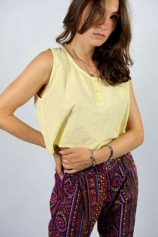 Boxy geschnittenes 80s Basic Tanktop aus reiner Baumwolle mit rundem Ausschnitt und Knöpfen vorn – von uns gecropped – die Farbe ist ein tolles Pastellgelb – für einen lockeren Look empfehlen wir das Top einer heutigen S