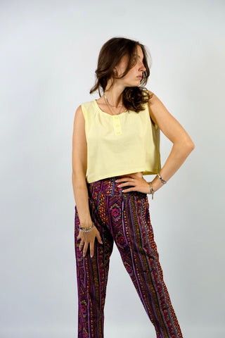 Boxy geschnittenes 80s Basic Tanktop aus reiner Baumwolle mit rundem Ausschnitt und Knöpfen vorn – von uns gecropped – die Farbe ist ein tolles Pastellgelb – für einen lockeren Look empfehlen wir das Top einer heutigen S