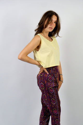 Boxy geschnittenes 80s Basic Tanktop aus reiner Baumwolle mit rundem Ausschnitt und Knöpfen vorn – von uns gecropped – die Farbe ist ein tolles Pastellgelb – für einen lockeren Look empfehlen wir das Top einer heutigen S