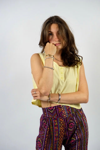 Boxy geschnittenes 80s Basic Tanktop aus reiner Baumwolle mit rundem Ausschnitt und Knöpfen vorn – von uns gecropped – die Farbe ist ein tolles Pastellgelb – für einen lockeren Look empfehlen wir das Top einer heutigen S