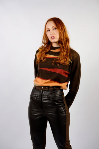 Dunkelbrauner 90s Pullover mit Stehkragen und tollem Grafikmuster in Orange, Rot, Beige und Gold – die angegebene Größe ist L, für einen lockeren Look empfehlen wir den Pullover jedoch eher einer heutigen M oder der Zwischengröße S/M