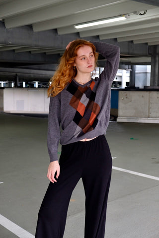 Grauer 90s Wollpullover mit V-Kragen und Rautenmuster in Rost/Orange, Hellgrau, Dunkelgrau, Schwarz und Brauntönen – für einen lockeren Look empfehlen wir den Pullover einer S/M