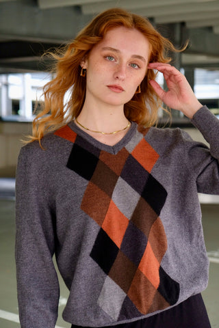 Grauer 90s Wollpullover mit V-Kragen und Rautenmuster in Rost/Orange, Hellgrau, Dunkelgrau, Schwarz und Brauntönen – für einen lockeren Look empfehlen wir den Pullover einer S/M