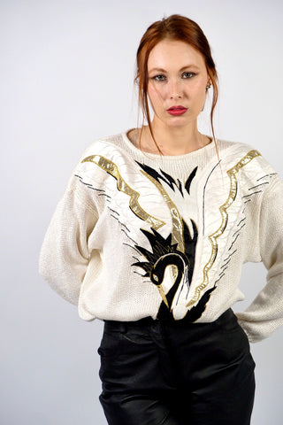 Atemberaubender, cremeweißer 80s Pullover aus hochwertiger Materialmischung (Ramie, Baumwolle und Viskose) – mit Schwanenmotiv auf der Vorderseite, das durch Applikationen in Schwarz, Weiß und Metallic-Gold-Tönen gestaltet wurde – die angegebene Größe ist L, tragbar von M bis L und ein absolutes Highlight