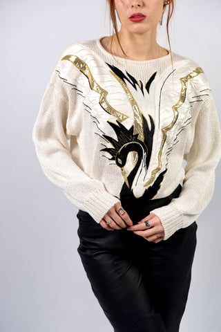 Atemberaubender, cremeweißer 80s Pullover aus hochwertiger Materialmischung (Ramie, Baumwolle und Viskose) – mit Schwanenmotiv auf der Vorderseite, das durch Applikationen in Schwarz, Weiß und Metallic-Gold-Tönen gestaltet wurde – die angegebene Größe ist L, tragbar von M bis L und ein absolutes Highlight