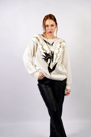 Atemberaubender, cremeweißer 80s Pullover aus hochwertiger Materialmischung (Ramie, Baumwolle und Viskose) – mit Schwanenmotiv auf der Vorderseite, das durch Applikationen in Schwarz, Weiß und Metallic-Gold-Tönen gestaltet wurde – die angegebene Größe ist L, tragbar von M bis L und ein absolutes Highlight