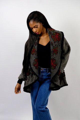 Dunkelgrauer 90s Cardigan made in Italy aus Wollmischung, toller offener Schnitt mit großem Kragen, umgeschlagenen Ärmeln und Boho Blumenmuster in Schwarz, Rot und Grün – wir empfehlen den Cardigan einer S bis M je nach gewünschter Passform – ein absolutes Highlight