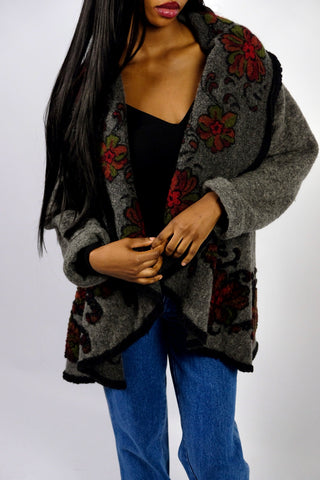 Dunkelgrauer 90s Cardigan made in Italy aus Wollmischung, toller offener Schnitt mit großem Kragen, umgeschlagenen Ärmeln und Boho Blumenmuster in Schwarz, Rot und Grün – wir empfehlen den Cardigan einer S bis M je nach gewünschter Passform – ein absolutes Highlight