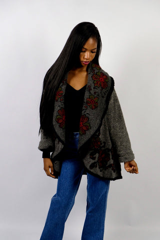 Dunkelgrauer 90s Cardigan made in Italy aus Wollmischung, toller offener Schnitt mit großem Kragen, umgeschlagenen Ärmeln und Boho Blumenmuster in Schwarz, Rot und Grün – wir empfehlen den Cardigan einer S bis M je nach gewünschter Passform – ein absolutes Highlight