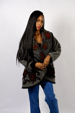 Dunkelgrauer 90s Cardigan made in Italy aus Wollmischung, toller offener Schnitt mit großem Kragen, umgeschlagenen Ärmeln und Boho Blumenmuster in Schwarz, Rot und Grün – wir empfehlen den Cardigan einer S bis M je nach gewünschter Passform – ein absolutes Highlight