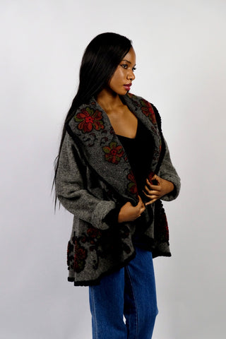 Dunkelgrauer 90s Cardigan made in Italy aus Wollmischung, toller offener Schnitt mit großem Kragen, umgeschlagenen Ärmeln und Boho Blumenmuster in Schwarz, Rot und Grün – wir empfehlen den Cardigan einer S bis M je nach gewünschter Passform – ein absolutes Highlight