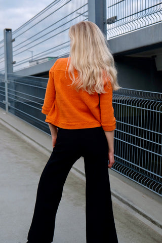 90s/00s Strickjäckchen in Orange, kurz und feminin geschnitten, mit ¾-Ärmeln und kleinen Eingrifftaschen seitlich – made in Italy und zu empfehlen für eine heutige XS