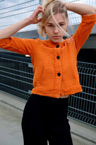 90s/00s Strickjäckchen in Orange, kurz und feminin geschnitten, mit ¾-Ärmeln und kleinen Eingrifftaschen seitlich – made in Italy und zu empfehlen für eine heutige XS