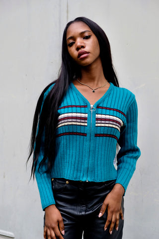 Kurz geschnittener 90s/00s Cardigan aus gerippter Baumwollmischung in Türkis (etwas grünlicheres Türkis, vgl. Farbe im Video), figurnahes Design mit V-Ausschnitt, Reißverschluss und Streifen in Schwarz, Weinrot, Creme und Graubraun – wir empfehlen den Cardigan einer XS