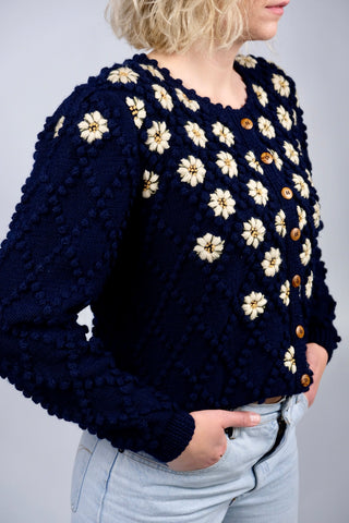 Atemberaubender 80s/90s Folklore Cardigan aus reiner Wolle in Marineblau mit tollem Popcorn-Strickmuster und detaillierten Blumenstickereien in Creme, Gelb und Grüntönen – die angegebene Größe ist L, fällt eher groß aus uns ist unserer Einschätzung nach auch von einer XL tragbar – ein seltenes Fundstück und absolutes Highlight in hervorragendem Zustand