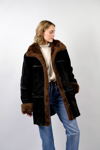 Schwarzer 00s Kurzmantel aus echtem Leder mit seitlichen Eingrifftaschen, Ziernähten und braunem Kunstfell an Kragen und Ärmeln, innen gesteppt – Größe M