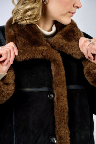 Schwarzer 00s Kurzmantel aus echtem Leder mit seitlichen Eingrifftaschen, Ziernähten und braunem Kunstfell an Kragen und Ärmeln, innen gesteppt – Größe M