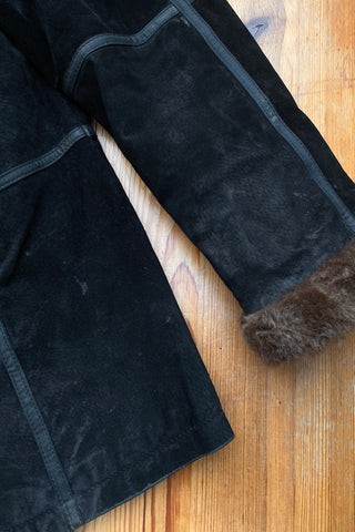 Schwarzer 00s Kurzmantel aus echtem Leder mit seitlichen Eingrifftaschen, Ziernähten und braunem Kunstfell an Kragen und Ärmeln, innen gesteppt – Größe M