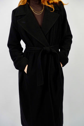 Hochwertiger, schwarzer 00s Wollmantel mit Kaschmir-Anteil – klassisch und elegant geschnitten, mit seitlichen Eingrifftaschen und Bindegürtel – die angegebene Größe ist L, fällt unserer Einschätzung nach kleiner aus; wir empfehlen den Mantel einer M oder S/M (bitte Maße beachten) – ein absolutes Highlight