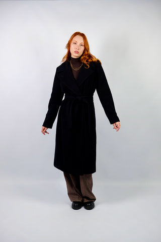 Hochwertiger, schwarzer 00s Wollmantel mit Kaschmir-Anteil – klassisch und elegant geschnitten, mit seitlichen Eingrifftaschen und Bindegürtel – die angegebene Größe ist L, fällt unserer Einschätzung nach kleiner aus; wir empfehlen den Mantel einer M oder S/M (bitte Maße beachten) – ein absolutes Highlight
